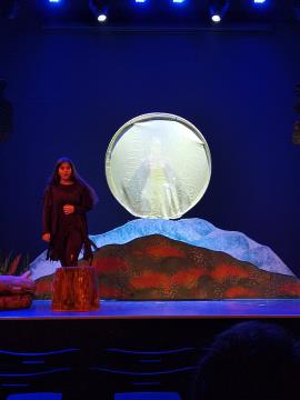 Prizor na odru - igralec in v ozadju pokrajina z luno